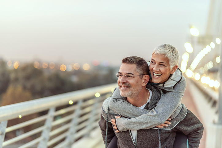 A cute couple smiling and enjoying the view during a piggyback ride