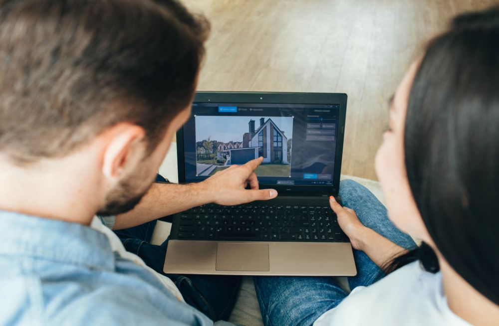 couple choosing new house using laptop