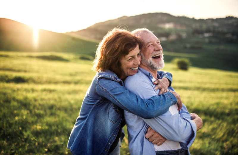 A senior couple hugging at sunset