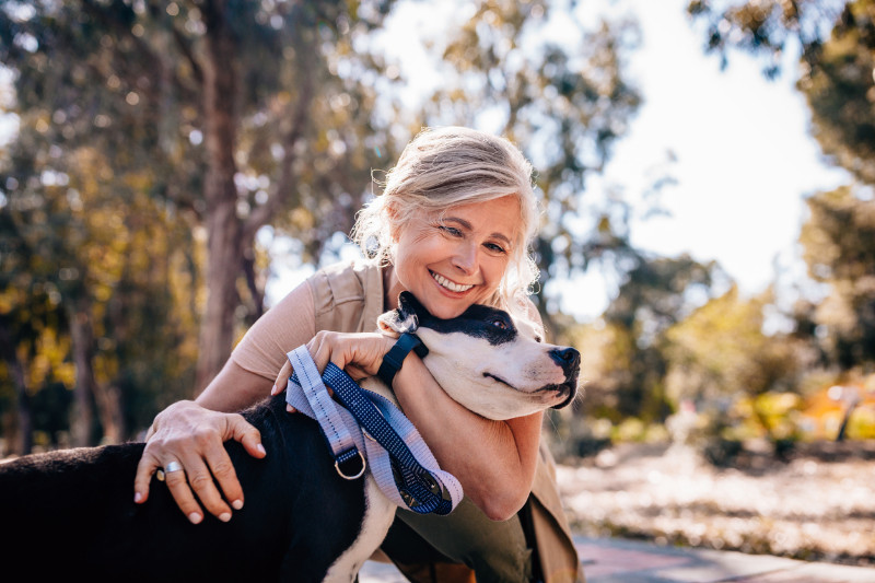 A woman happily hugging her dog