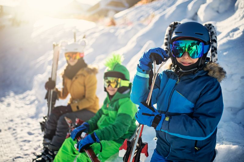 happy kids getting ready to skiing on winter day