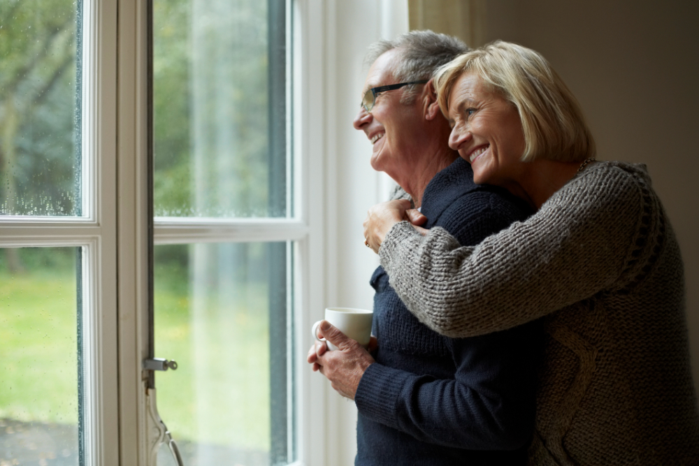 Senior woman embracing man in front of door